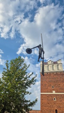 Sandomierz Polonya - 30 Ağustos 2025: Sandomierz 'in zengin tarihi ve kültürünü gözler önüne seren büyük bir tencereyi tutan eşsiz bir heykel.