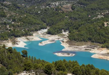 Guadalest rezervuarının turkuaz sularının havadan görünüşü Guadalest İspanya 'nın yemyeşil ormanlarıyla çevrilidir. Doğal güzelliği olan pitoresk bir manzara..