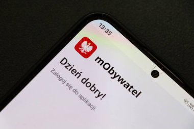 Varşova Polonya - 2 Ağustos 2025: Dijital vatandaşlığı sembolize eden bir karşılama mesajı ve logo içeren mObywatel uygulama arayüzünü gösteren bir cep telefonunun yakın çekimi.