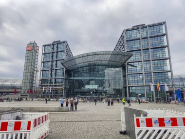 Berlin Almanya - 9 Nisan 2025: Berlin Hauptbahnhof, gezginlerle dolu ve kentsel faaliyetlerle çevrili modern mimarinin yer aldığı büyük bir demiryolu istasyonu..