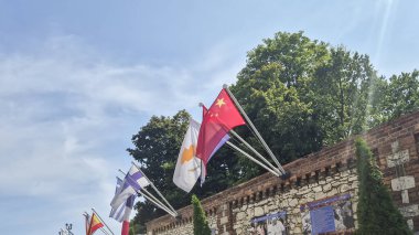 Czestochowa Poland - August 9 2025: Flags of various countries fluttering against a clear blue sky illustrating multiculturalism and international relations in a public space.
