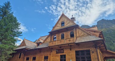Zakopane Poland - September 13 2025: Traditional wooden architecture showcased in a stunning mountain setting with clear blue skies highlighting regional craftsmanship.
