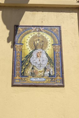 Alicante Spain - July 17 2025: A vibrant tile mural depicting the Virgin of Esperanza adorns a wall in a bustling street showcasing religious art and cultural heritage.