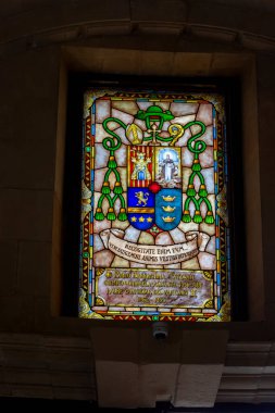 Alicante Spain - July 17 2025: Stained glass window featuring a vibrant coat of arms with intricate detailing and colors showcasing historical significance and artistry.