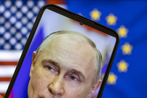Warsaw Poland - September 17 2025: Close-up of a smartphone displaying Vladimir Putins image highlighted against symbols of the US and EU referencing the Ukraine war.