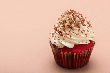 Çikolata parçaları tek renk arka plan üzerinde beyaz kremalı Cupcake kırmızı kadife süslenmiş