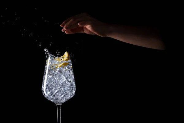 Female Hand Splashing Lemon Iced Water Black Background — Stock Photo, Image
