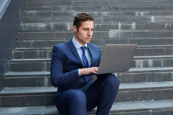 Seriöser Erfolgreicher Junger Geschäftsmann Arbeitet Modernem Laptop Und Sitzt Auf — Stockfoto