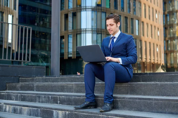 Glücklicher Erfolgreicher Junger Geschäftsmann Arbeitet Mit Modernem Laptop Benutzt Kopfhörer — Stockfoto