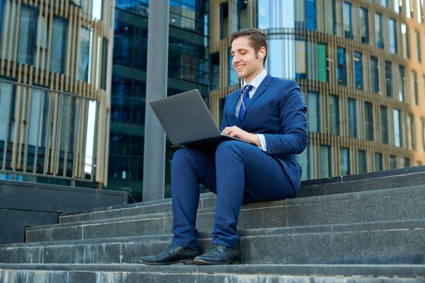 Glücklicher Erfolgreicher Junger Geschäftsmann Arbeitet Mit Modernem Laptop Benutzt Kopfhörer — Stockfoto