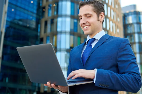 Glücklicher Erfolgreicher Junger Geschäftsmann Arbeitet Modernem Laptop Außerhalb Von Wolkenkratzern — Stockfoto