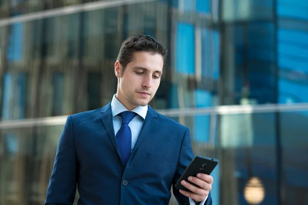 Seriöser Junger Geschäftsmann Anzug Schreibt Sms Telefon Vor Dem Gläsernen — Stockfoto