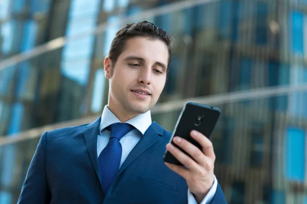 Schöner Geschäftsmann Anzug Schreibt Sms Vor Modernem Gebäude — Stockfoto