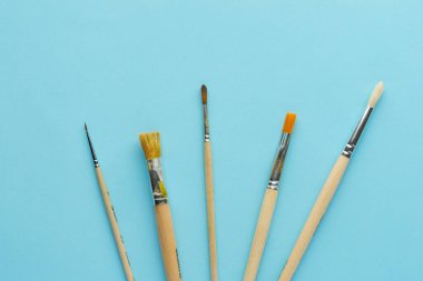 Mavi arkaplanda farklı sanat fırçaları 