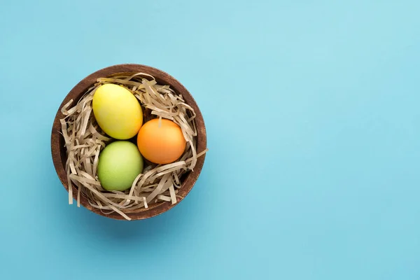 Malovaná Velikonoční Vajíčka Kulatém Dřevěném Talíři Řemeslnou Seno Modrém Pozadí — Stock fotografie