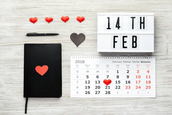 ハート 木製の背景モックアップ上のビューでカレンダーと黒のノートブック バレンタインデー 2月14日 — ストック写真