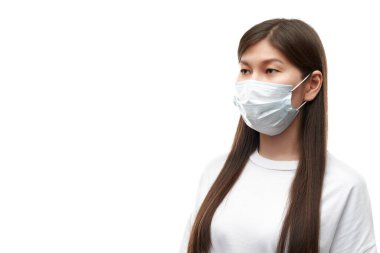 Beyaz arka planda tıbbi maske takan Asyalı genç bir kadın izole edilmiş.