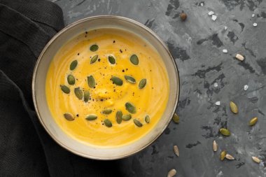 Tohumlu kremalı kukla çorbası gri arka plan ve peçeteyle hazır. Üst görünüm