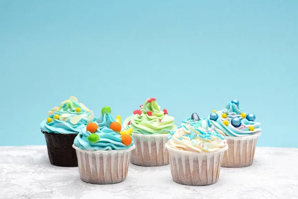 Mavi Arka Planda Karamel Şekerlerle Süslenmiş Renkli Kekler Metin Için — Stok fotoğraf