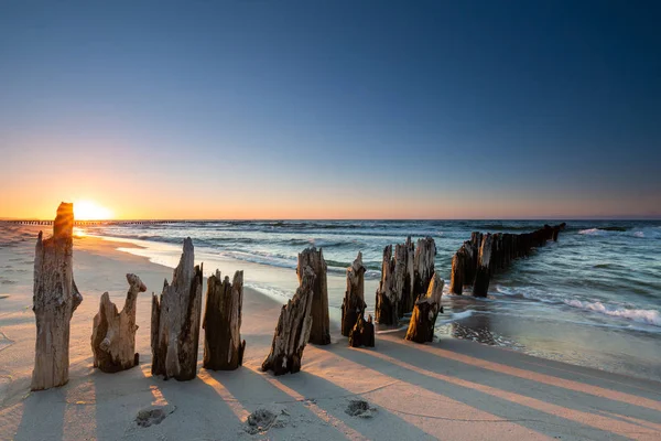 Petit brise-lames en bois au coucher du soleil sur la mer Baltique — Photo