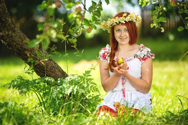Venkovská dívka v tradičním oblečení na jablku — Stock fotografie