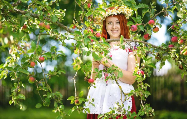 Elma ağacında geleneksel bir kıyafet kırsal kız — Stok fotoğraf