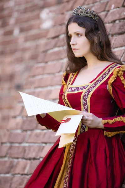 Женщина в платье эпохи Возрождения читает письмо — стоковое фото