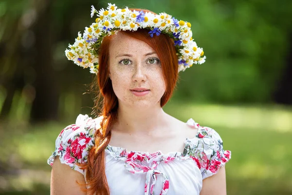 Retrato de una mujer pecosa pelirroja en una corona de flores —  Fotos de Stock