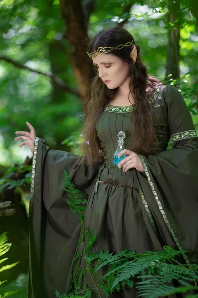 Elfo con una botella de poción mágica en el bosque — Foto de Stock