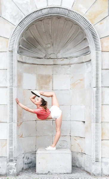 Красивая гимнастическая женщина растягивается на открытом воздухе — стоковое фото