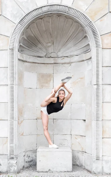 Mooie gymnastische vrouw stretching buitenshuis Stockfoto