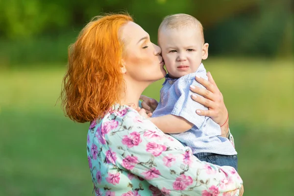 红头发的母亲与儿子在手 图库图片