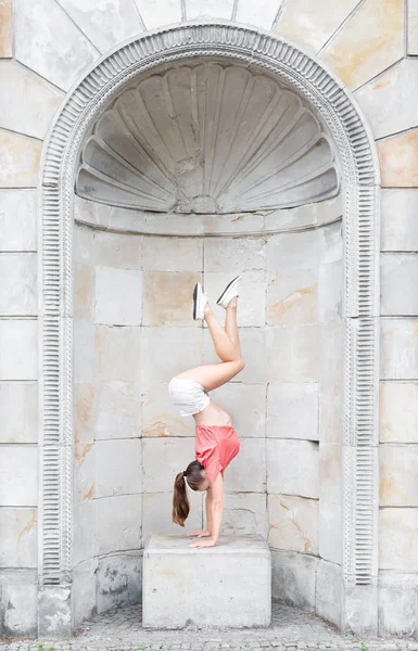 Ginástica mulher exercitando ao ar livre em um fundo de parede de mármore — Fotografia de Stock