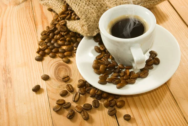 桌子上一杯咖啡和咖啡豆的图片 — 图库照片