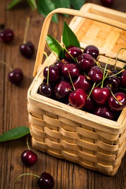 Kiraz bir hasır sepet arka planda. Seçici odak.