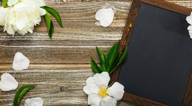 Taze beyaz şakayık çiçekleri siyah kara tahta arka plan kart kavramı ile. Seçici odak.