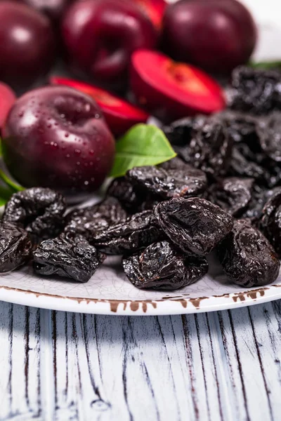 Dried Plums Pitted Prunes and Fresh Plums Background. Selective focus.