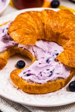 Continental kahvaltı Croissants ve yaban mersini krem peynir ile yayıldı. Seçici odak.
