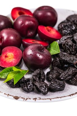 Kurutulmuş erik çekirdeksiz kuru erik içinde kalp şeklinde kase izole beyaz zemin üzerinde. Seçici odak.