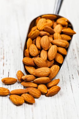 Kepçe organik çiğ badem fındık dolu. Seçici odak.