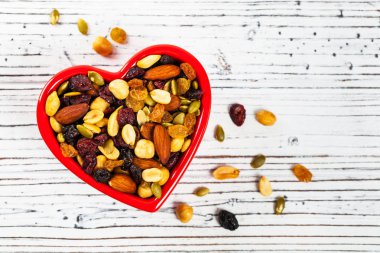 Enerji karışımı Trail Mix ile fındık ve kuru meyve kalbinde kase şeklinde. Seçici odak.