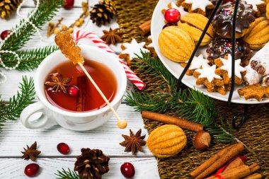 Noel tatil çay saati. Tarçın, anason ve bal ile kış sıcak baharatlı çay fincan. Seçici odak.