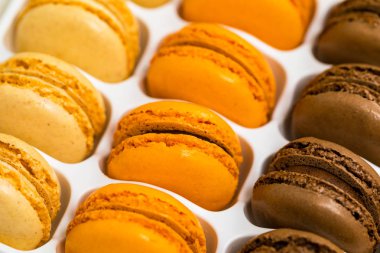 Renkli Macaroons çikolata, fıstık, vişne, portakal, vanilya lezzet arka plan. Seçici odak.