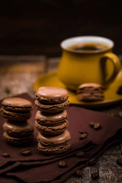 木製のテーブルの上にコーヒー豆とダークチョコレートマカロン 選択的焦点 — ストック写真