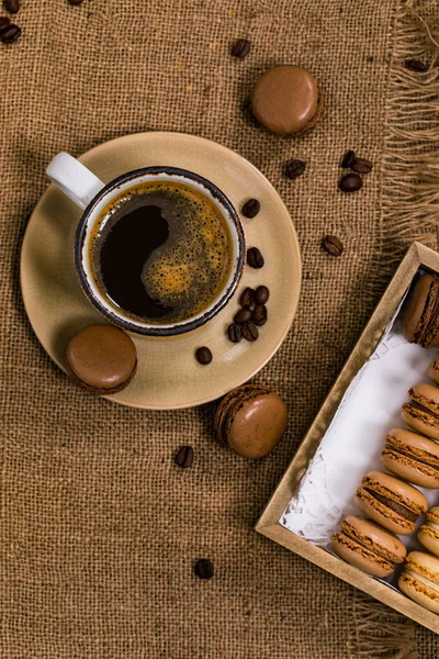木製のテーブルの上にコーヒー豆とダークチョコレートマカロン 選択的焦点 — ストック写真