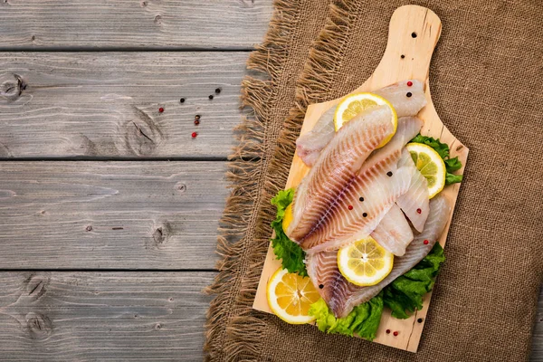 Whitefish Tilapia Fish Raw Fillet on Wooden Background. Selective focus.