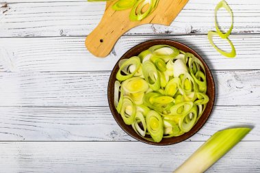 Beyaz Ahşap Arka Plan üzerine Dilimlenmiş Pırasa Yeşil Soğan. Seçici odaklama.