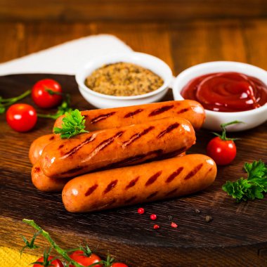 Grilled Smoked Sausages on Wooden Background. Selective focus. clipart