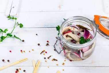 Baharatlı, turplu ve ahşap arka planda kırmızı soğanlı marine edilmiş ringa balığı. Seçici odak.