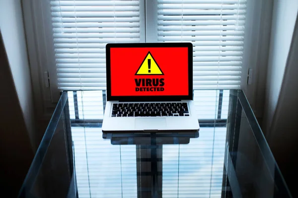 computer virus, alert sign on the screen of laptop in dark room